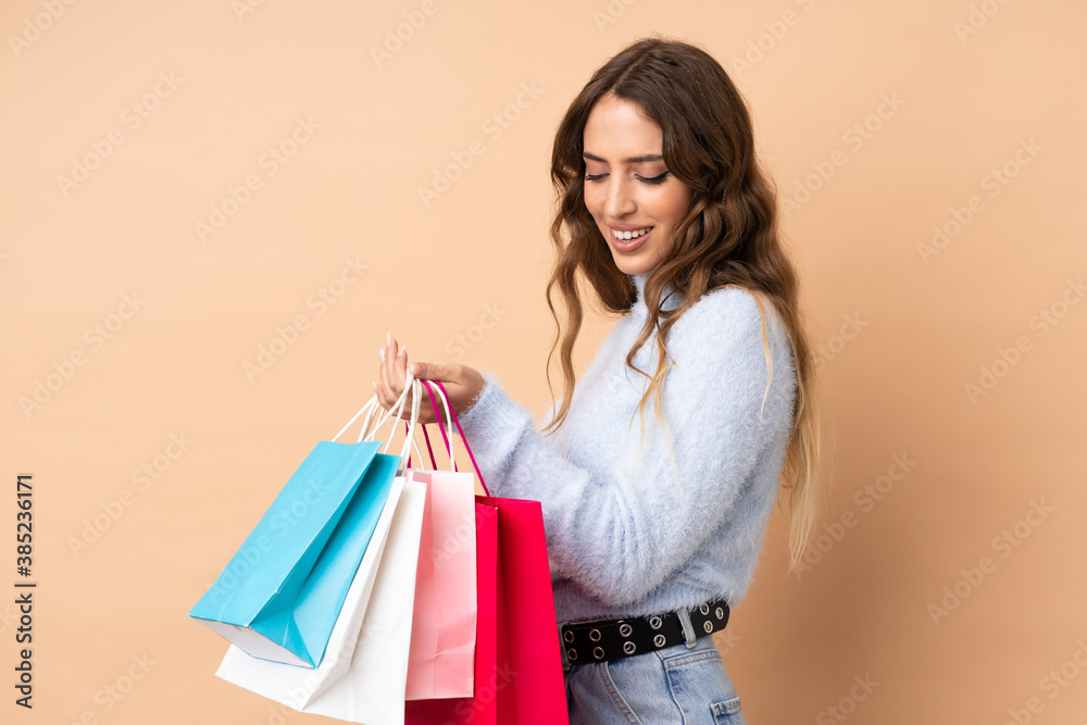 Young woman over isolated background holding shopping bags