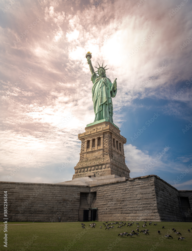 Obraz premium Shot of the Statue of Liberty in New York City, Usa. The shot is taken during a beautiful sunny day with a blue sky and white clouds in the background