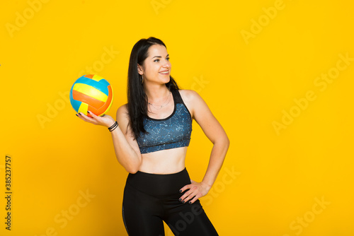 Young beautiful volleyball player isolated on yellow in studio © Ivan Zelenin