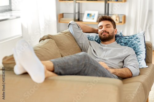 people and leisure concept - young man sleeping on sofa at home © Syda Productions
