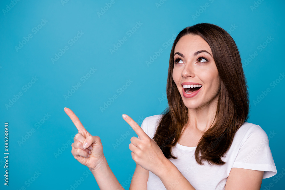 Closeup photo of attractive funny lady good mood directing fingers side up empty space presenting novelty banner sale shopping wear casual white t-shirt isolated blue color background Closeup photo of attractive funny lady good mood directing fingers side up empty space presenting novelty banner sale shopping wear casual white t-shirt isolated blue color background
