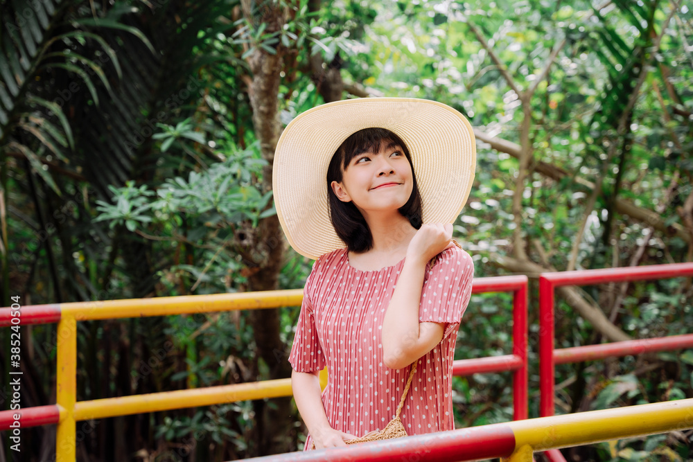 Beautiful asian thai woman short dark hair wear a big hat in nature. Local traveler.