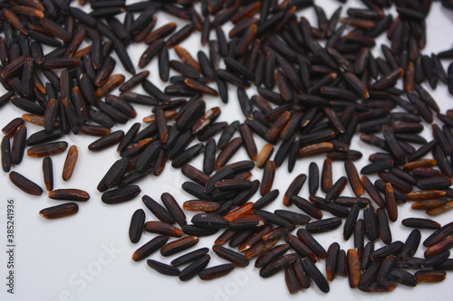 Useful black long unpolished wild rice sprinkled on a white plate. Healthy food, healthy cereals for every day is natural rice.