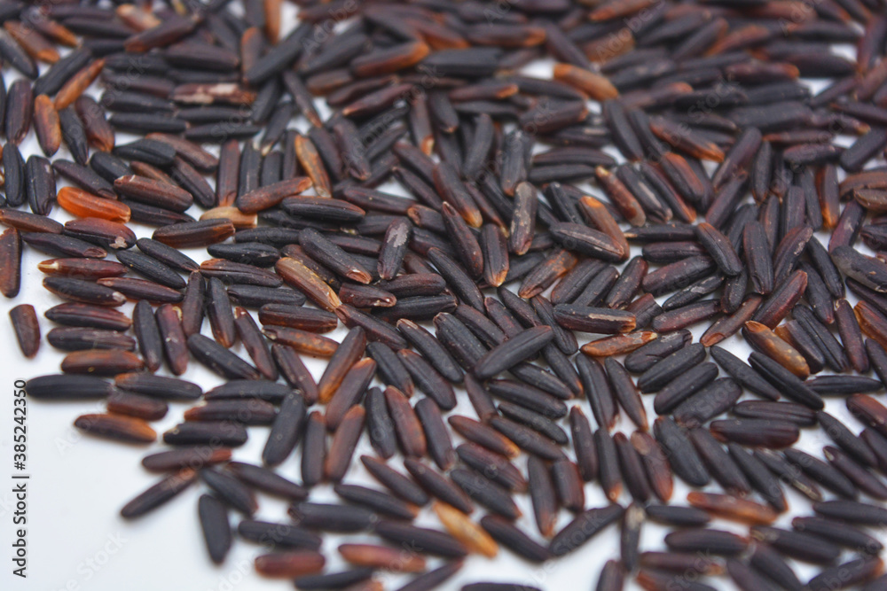 Useful black long unpolished wild rice sprinkled on a white plate. Healthy food, healthy cereals for every day is natural rice.