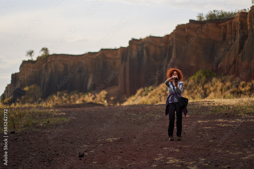 Naklejka premium Tourist lady with camera at sunset
