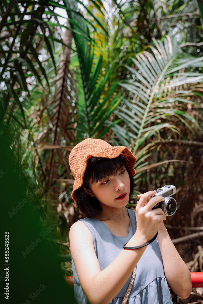Young asian Thai woman traveler with vintage camera at country side road.