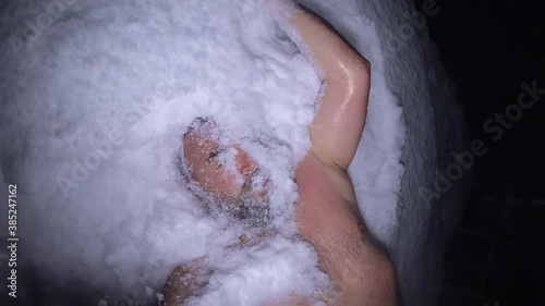 A man throws snow on his face