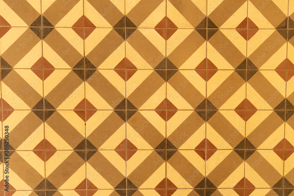 Geometric pattern of vintage floor tiles in yellow and brown