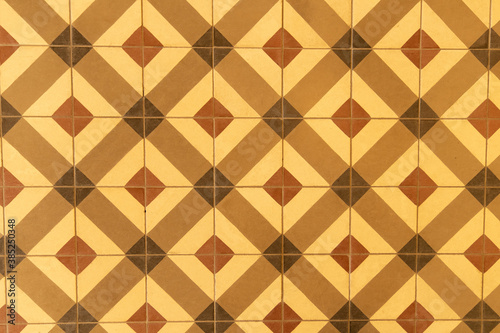 Geometric pattern of vintage floor tiles in yellow and brown