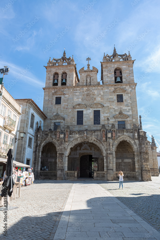Main façade of Braga Cathedral. Entrance gallery with three gothic arches, 15th century, towers and upper storeys, early baroque, front piazza and tourist people