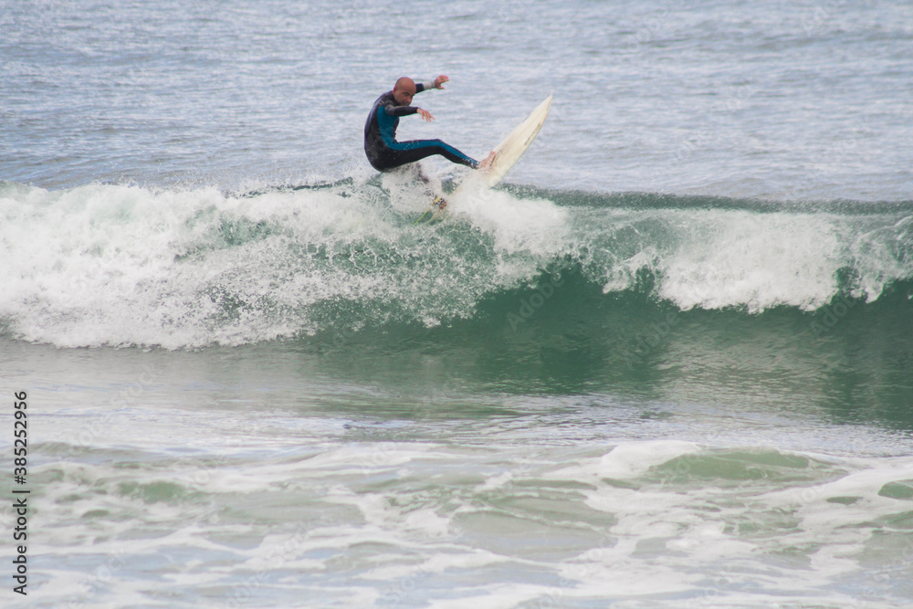 Adult performing surf maneuver. Father and son sharing surf session in Les Landes France Adult performing surf maneuver. Father and son sharing surf session in Les Landes France
