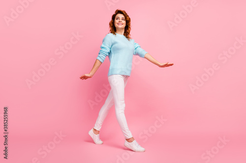 Full length body size view of her she nice-looking attractive lovely winsome cute glad cheerful cheery wavy-haired girl walking spending free time isolated over pink pastel color background © deagreez