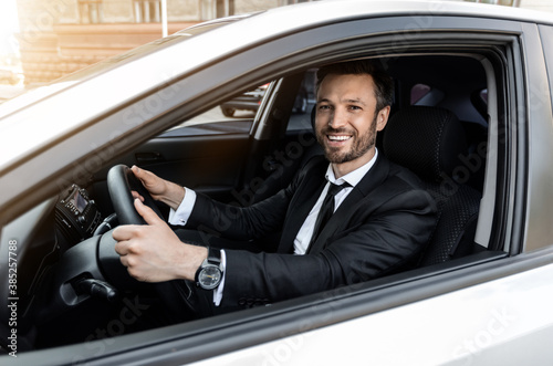 Excited businessman driving car to airport, going on business trip © Prostock-studio