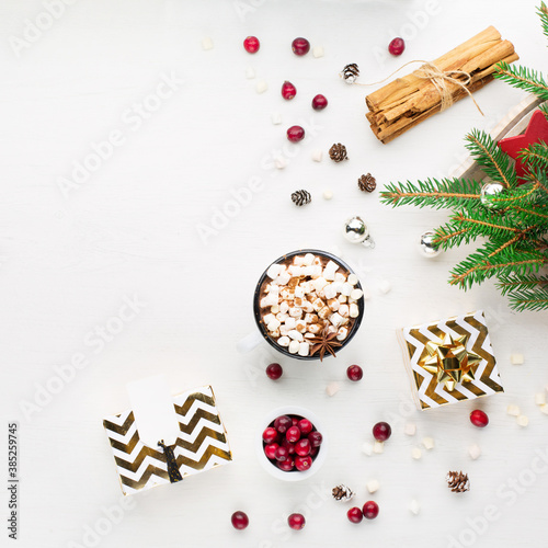 Christmas decoration, cup of coffee, homemade sweet gingerbread cookies, pine cones and branches on white wooden background.