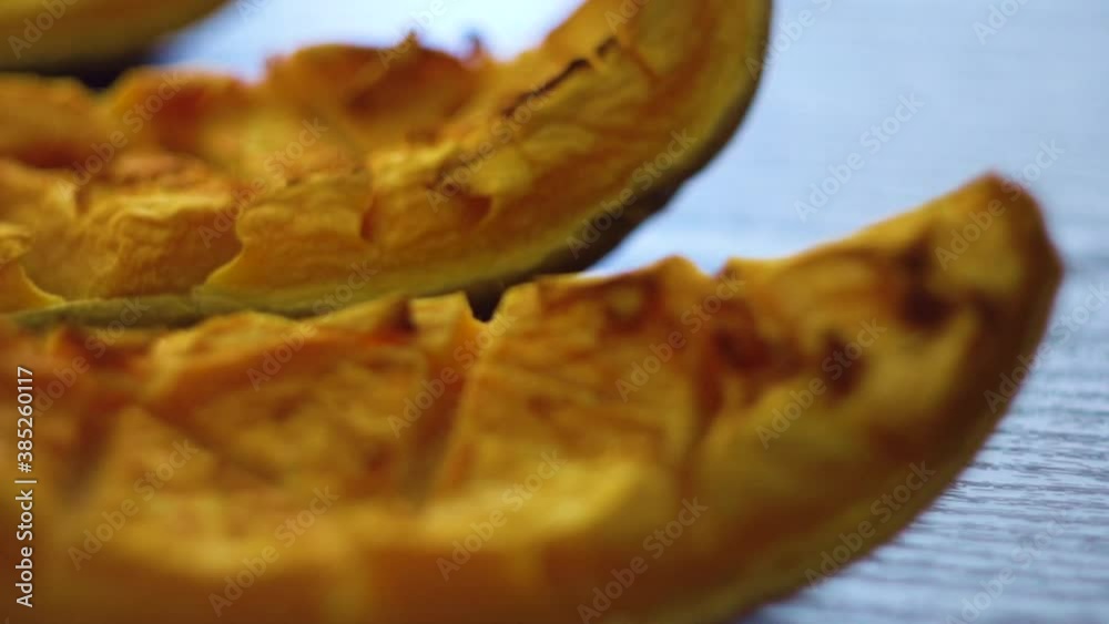 Roasted pumpkin slices. Freshly baked and juicy slices of pumpkin on the black table. Autumn flavors. Simple food concept. Baked in the oven. Healthy vegetarian food. Roasted pumpkin slices. Freshly baked and juicy slices of pumpkin on the black table. Autumn flavors. Simple food concept. Baked in the oven. Healthy vegetarian food.