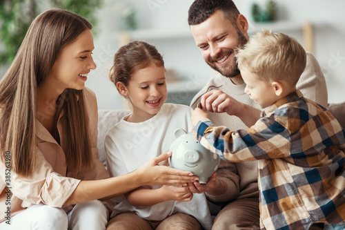 Bild auf Leinwand financial planning   family mother father and children with piggy Bank at home