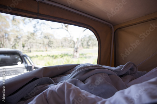 View from a caravan campervan tent of a meadow, trees at sunset female woman legs