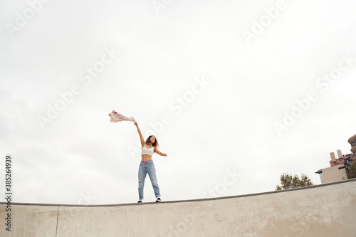 Young woman in freedom waving her shirt. Copy space. Freedom concept.