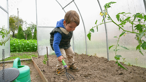 Child with a small shoulder blade in a greenhouse © SYARGEENKA