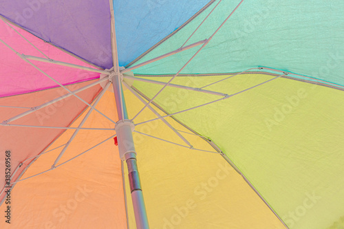 Colorful beach umbrella close up background texture. Rainbow colors.