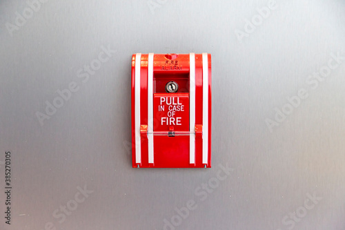 Fire alarm switch on white wall. Fire alarm equipment box on cement wall.