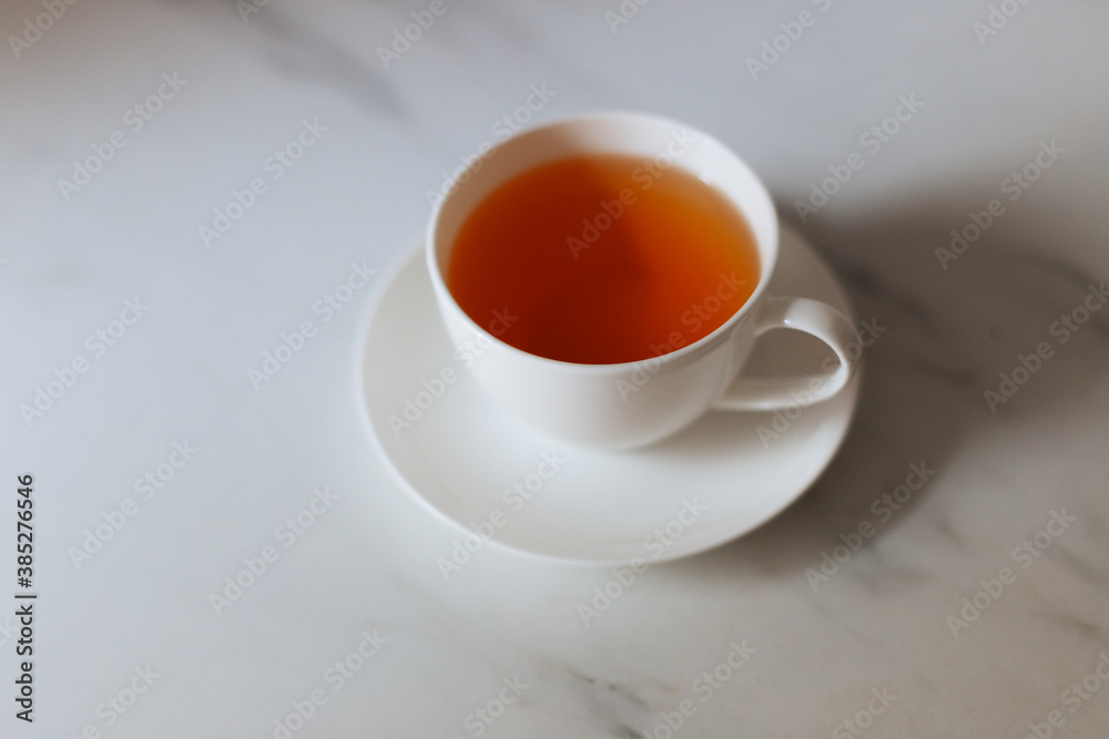 Top view of a cup of hot tea with copy space.Hot tea is in a white glass placed on a white background. There is space for the message. White background.