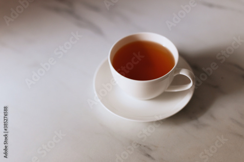 Top view of a cup of hot tea with copy space.Hot tea is in a white glass placed on a white background. There is space for the message. White background.