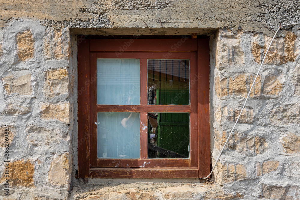 Vintage wooden window on a rustic cabine stone wall