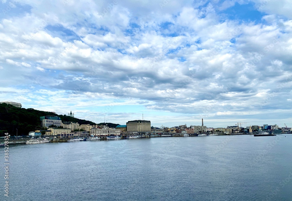 view of the town, view of the promenade among the blue water and the sky with clouds