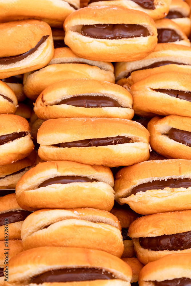 Freshly baked buns with chocolate or nougat cream filling in Italian sunday food market (Hot dog with chocolate)