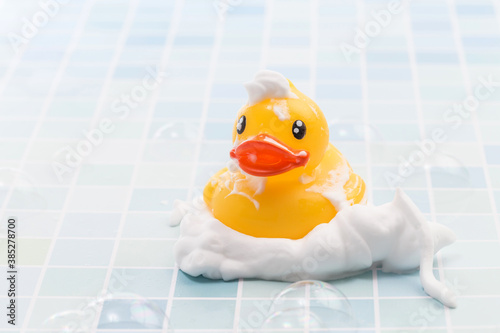 Fotografie A toy duck covered in foam taking a bath