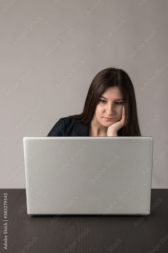 Young woman in blue with laptop.