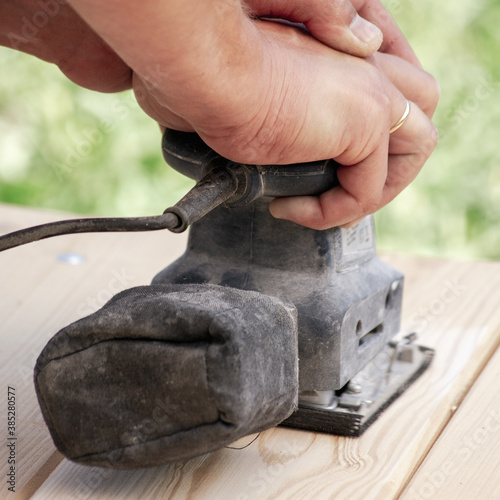 Carpenters use tools for wood products. Processing of the wooden surface of the table.