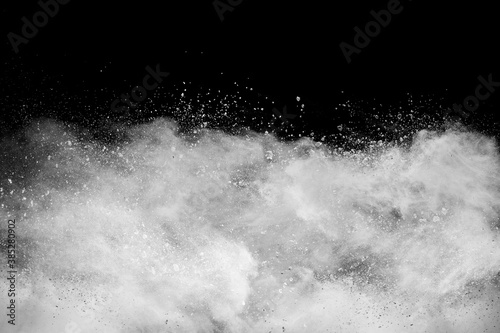 White powder explosion cloud against black background.