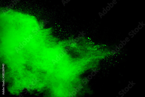 Green powder explosion cloud on black background.