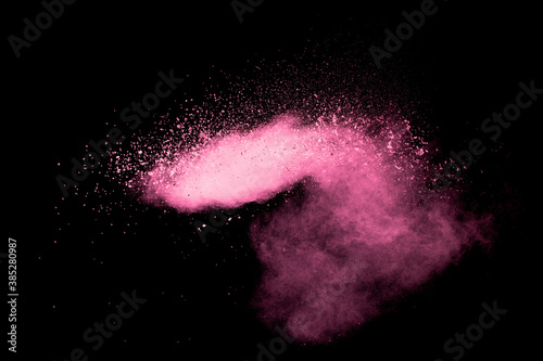 Pink dust particles splash on black background.Pink powder splash.