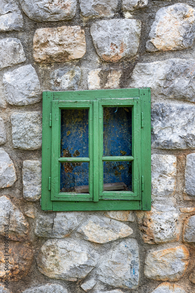 Vintage wooden window on a rustic cabine stone wall