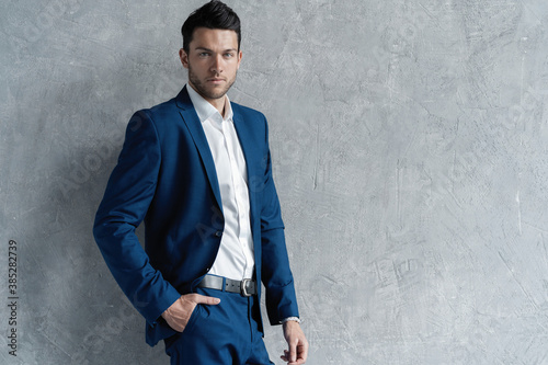 Handsome man wear blue suit isolated on grey background