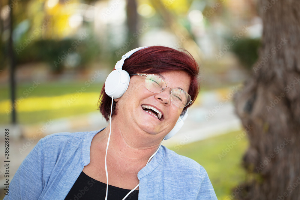 cheerful mature woman with phone and headset.
cheerful mature woman with phone and headset.