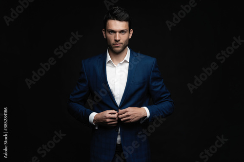 Handsome man wear blue suit isolated on black background photo