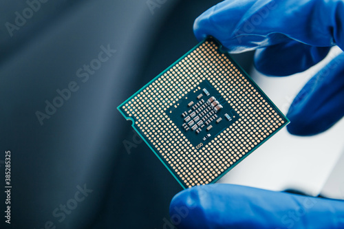 Photography Close-up view on a new semiconductor microchip in gloved hand of computer scientist