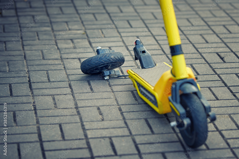 Foto de Electric scooter with broken rear wheel on city street. Damaged