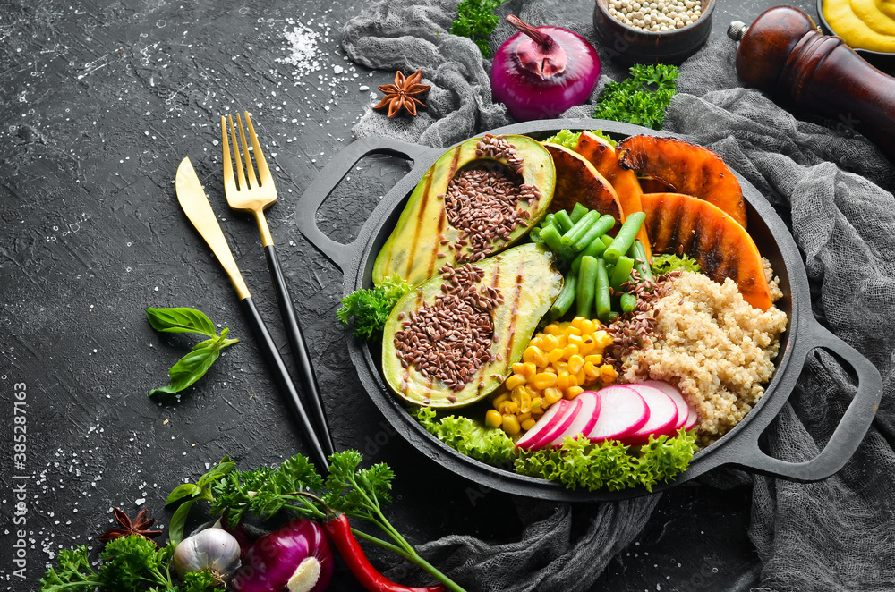 Vegan bowl: quinoa, avocado, pumpkin with beans and corn in a black bowl. Diet. Top view. Free space for text. Vegan bowl: quinoa, avocado, pumpkin with beans and corn in a black bowl. Diet. Top view. Free space for text.