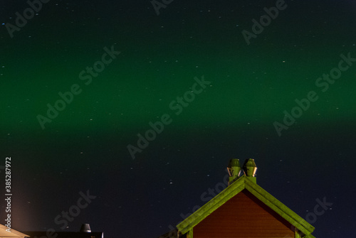 A little green northern light in Norway over a house