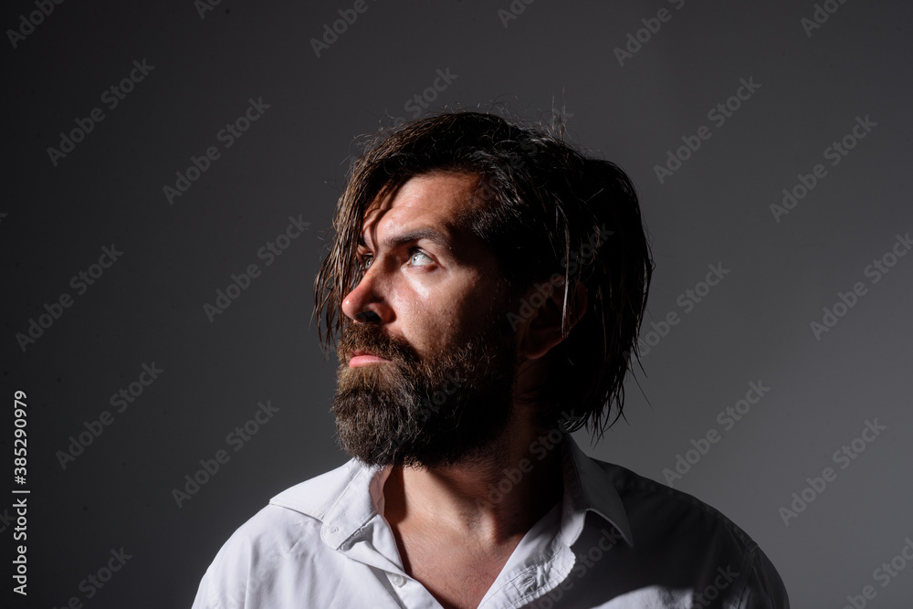 Brutal bearded man. Silhouette handsome man. Barber Shop. Fashion. Trendy clothes. Bearded man in white shirt. Pensive man.