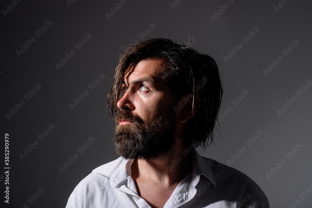 Obraz premium Brutal bearded man. Silhouette handsome man. Barber Shop. Fashion. Trendy clothes. Bearded man in white shirt. Pensive man.