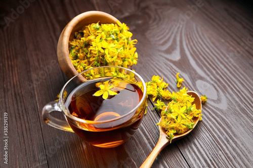 Cup with hypericum perforatum or St Johns wort tea with fresh flowers photo