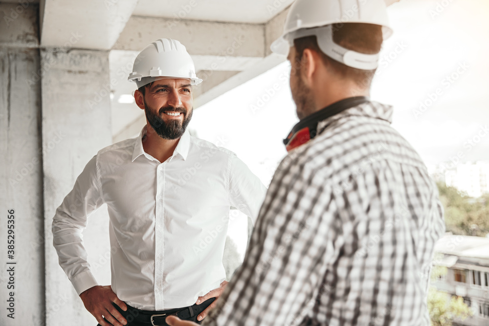 Entrepreneur speaking with worker on construction site Entrepreneur speaking with worker on construction site