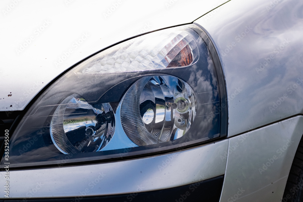 Large car headlights close-up, technical road lighting day and night. Front and rear colored lights and turn signals