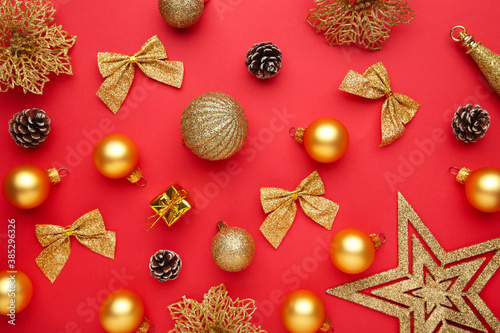 Christmas composition made of christmas gold decoration on red background. Flat lay